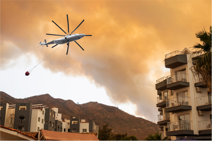 A helicopter putting out a wildfire in CA near a mountain and condos
